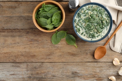 Photo of Tasty spinach dip on wooden table, flat lay. Space for text