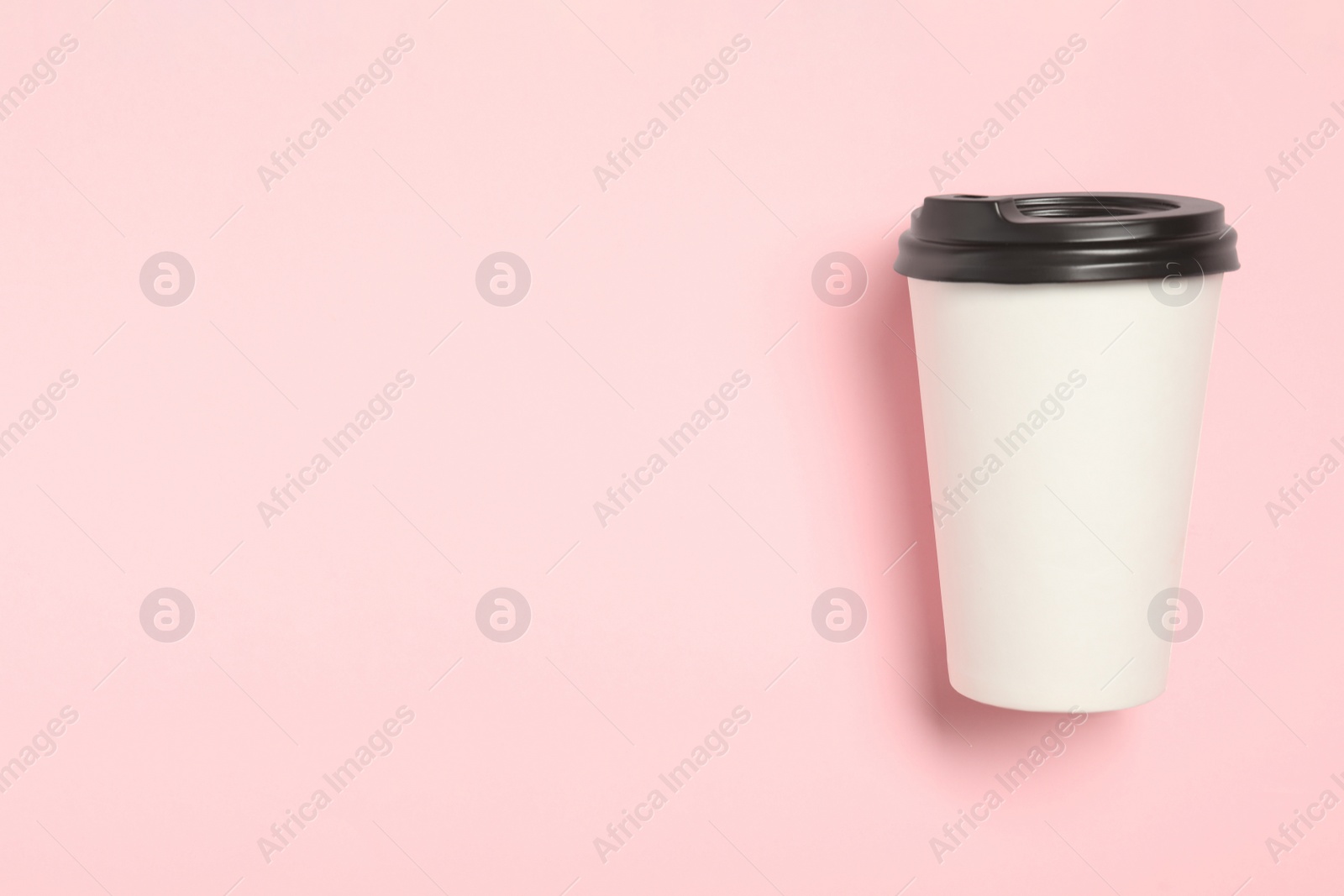 Photo of Takeaway paper coffee cup on pink background, top view. Space for text