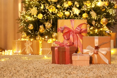 Many gift boxes near decorated Christmas tree at home. Space for text