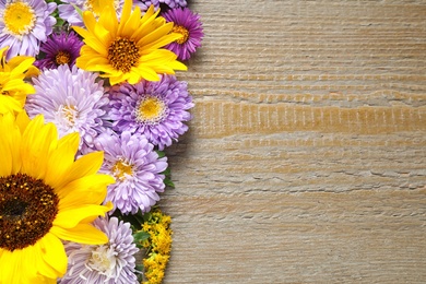 Flat lay composition with beautiful asters and sunflowers on wooden table. Space for text