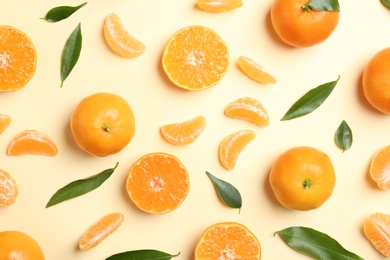 Photo of Composition with tangerines and leaves on color background, flat lay