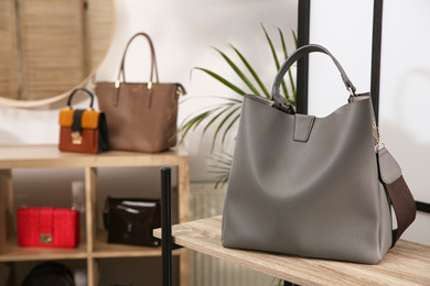 Photo of Grey woman's bag on wooden shelf in store