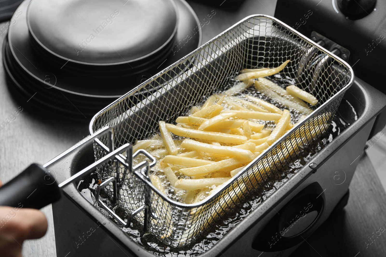 Photo of Cooking delicious french fries in hot oil