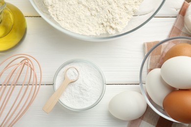 Photo of Flat lay composition with baking powder and eggs on white wooden table