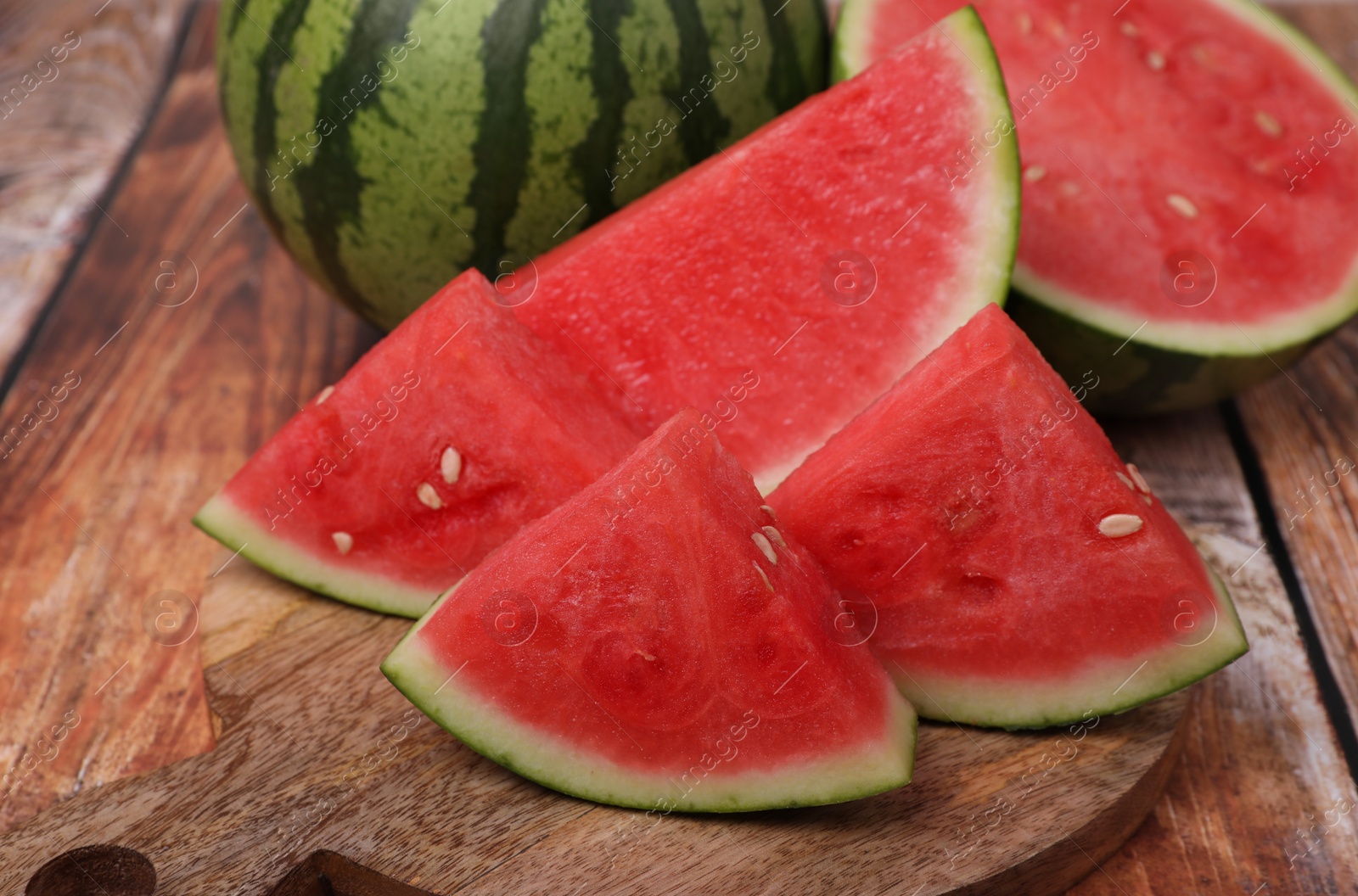 Photo of Pieces of juicy ripe watermelons on wooden table, closeup