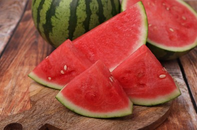 Photo of Pieces of juicy ripe watermelons on wooden table, closeup