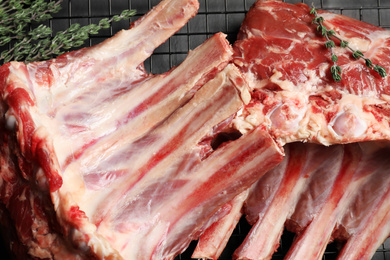 Raw ribs with thyme on cooling rack, closeup