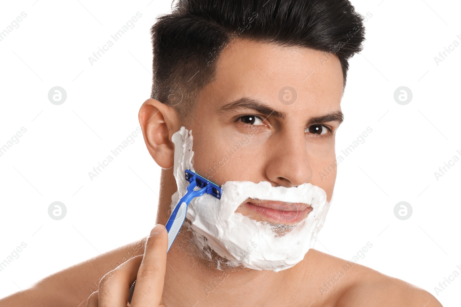 Photo of Handsome man shaving with razor on white background, closeup