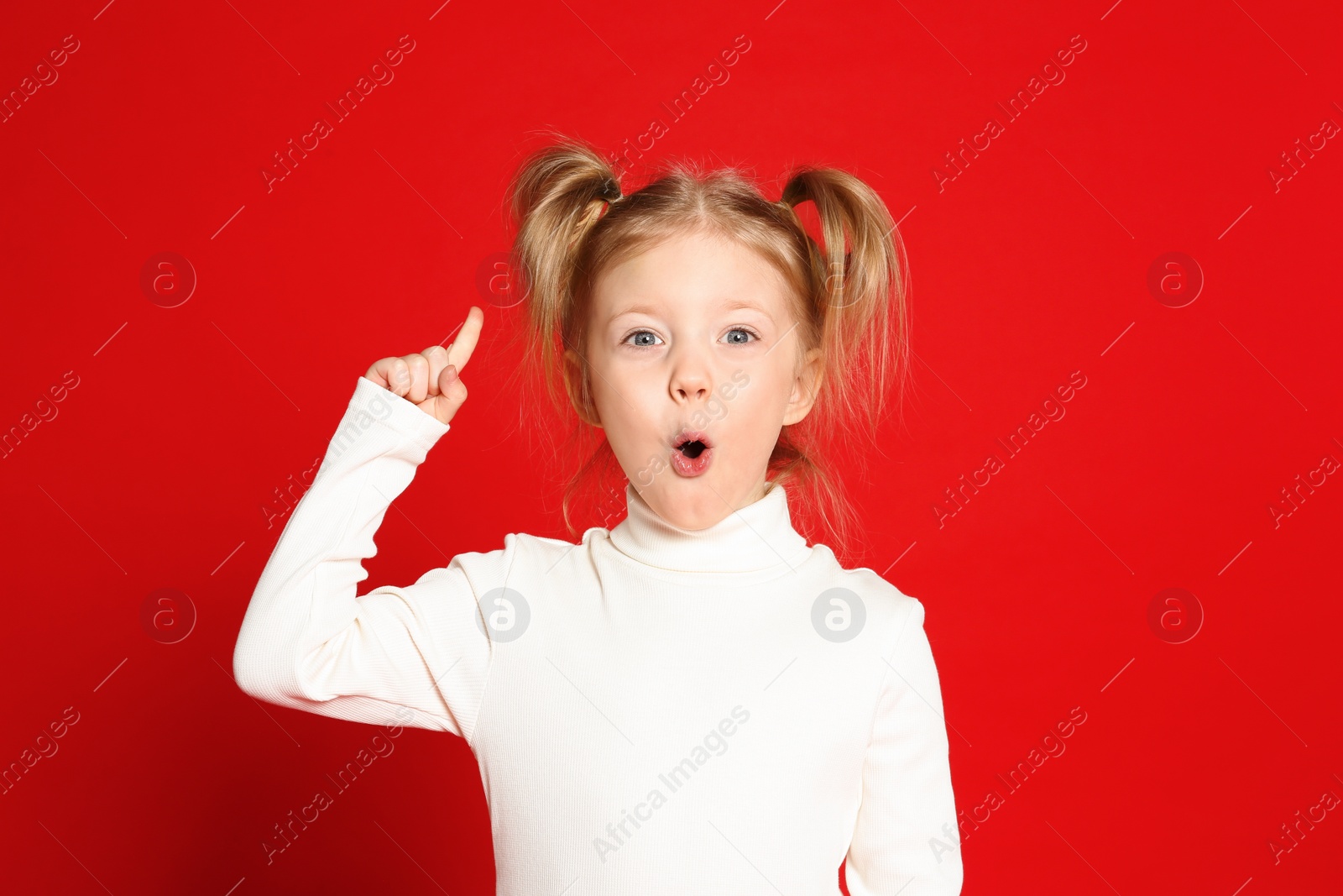 Photo of Portrait of cute little girl on red background