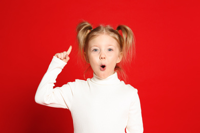 Photo of Portrait of cute little girl on red background