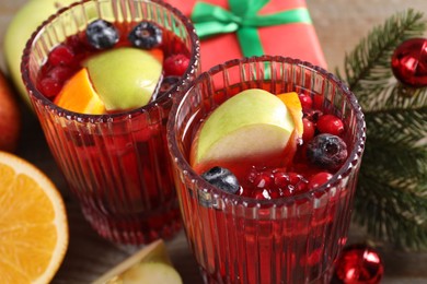 Aromatic Christmas Sangria drink in glasses on table, closeup