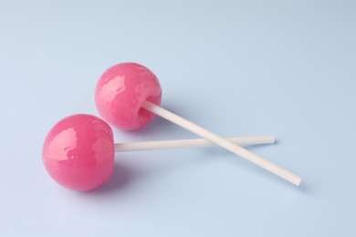 Photo of Tasty lollipops on light blue background, closeup