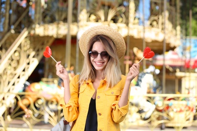 Beautiful woman with candies having fun at amusement park