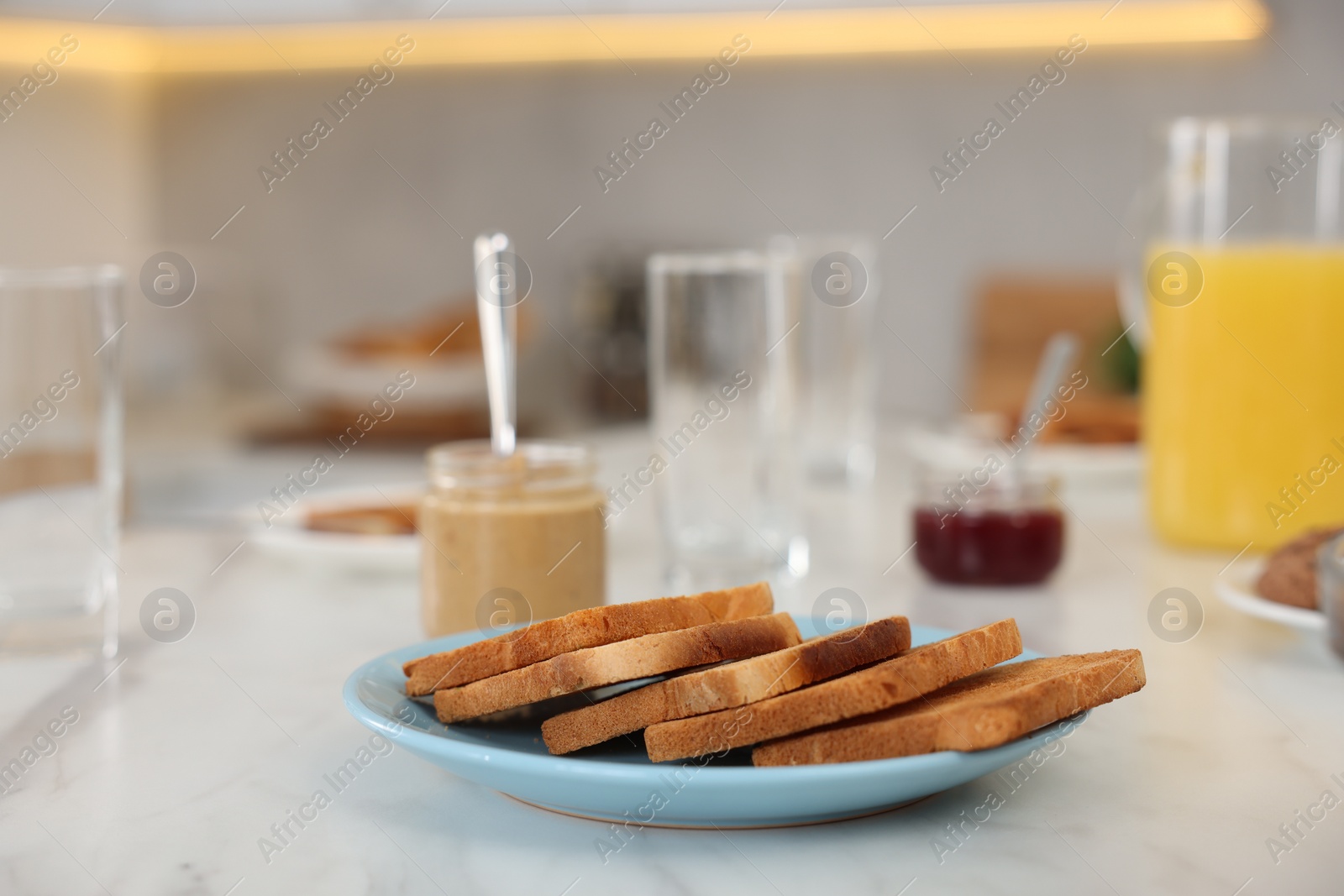 Photo of Breakfast served in kitchen. Crunchy toasts and nut paste on white marble table