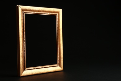 Photo of Empty golden frame on black background. Space for design