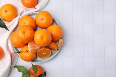 Photo of Fresh juicy tangerines on white tiled table, flat lay. Space for text