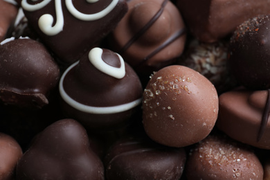 Photo of Different tasty chocolate candies as background, closeup