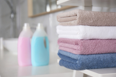 Photo of Stack of fresh towels on shelf in bathroom, space for text. Laundry day