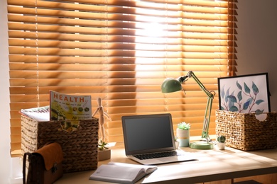 Comfortable workplace with laptop near window at home