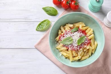Photo of Delicious pasta with tomato sauce served on white wooden table, flat lay. Space for text