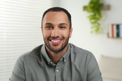 Photo of Young man having online video call at home, view from camera