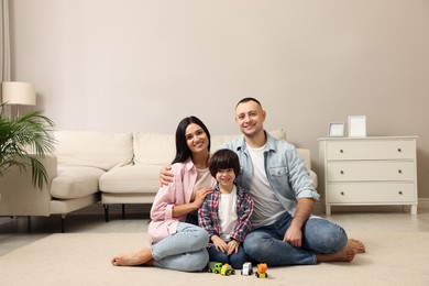 Photo of Happy family sitting on floor at home