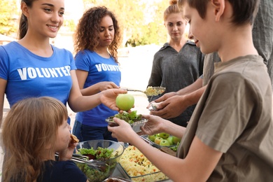 Photo of Volunteers serving food to poor people outdoors