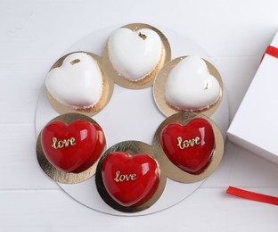 Photo of St. Valentine's Day. Delicious heart shaped cakes on white wooden table, top view