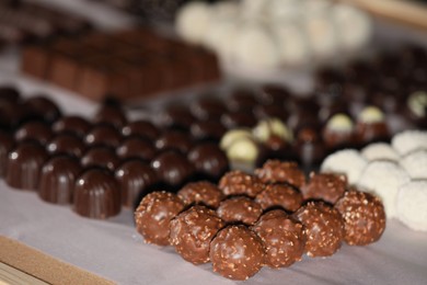 Photo of Many delicious chocolate candies on table, closeup. Production line