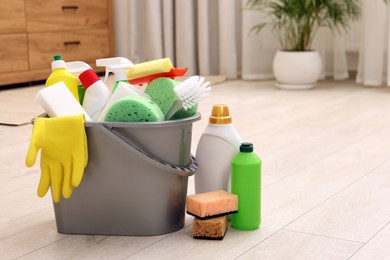 Photo of Different cleaning supplies in bucket on floor