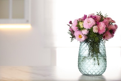 Photo of Vase with beautiful chrysanthemum flowers on table in kitchen, space for text. Interior design