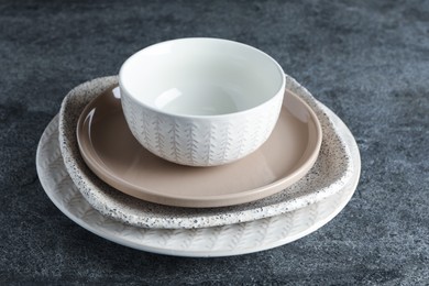 Photo of Stack of clean dishes on grey table