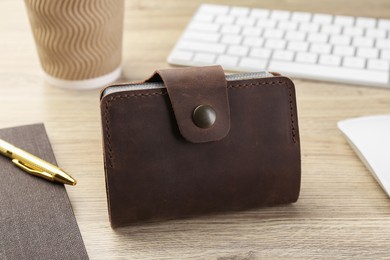 Photo of Leather business card holder and stationery on wooden table