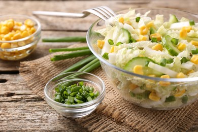 Photo of Tasty salad with Chinese cabbage served on wooden table, closeup