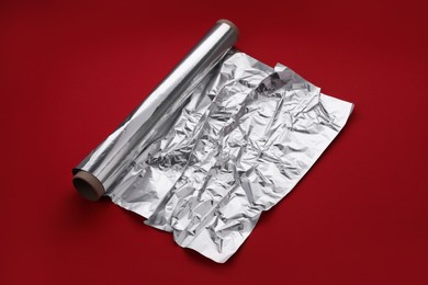 Photo of One roll of aluminum foil on red background