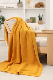 Photo of Comfortable sofa with orange blanket in living room