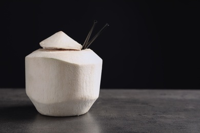 Photo of Fresh coconut drink in nut on table against black background