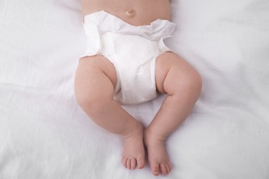 Photo of Little baby in diaper on bed, closeup