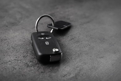 Photo of Modern car flip key with trinket on grey background. Space for text