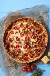 Photo of Delicious homemade prosciutto quiche and ingredients on table, flat lay