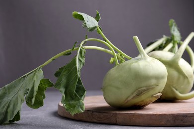 Photo of Whole ripe kohlrabi plants on grey table, closeup