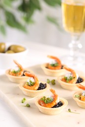 Photo of Delicious canapes with shrimps and black caviar on table, closeup