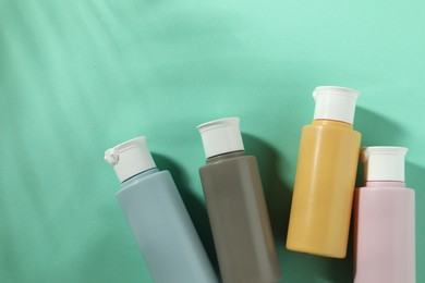 Photo of Cosmetic travel kit on turquoise background, top view