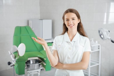 Photo of Portrait of smiling young gynecologist at workplace in clinic. Space for text
