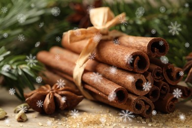 Image of Different spices and fir tree branches on wooden table, closeup. Cinnamon, anise, cardamom