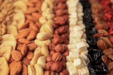 Photo of Different tasty nuts and dried fruits on beige background, closeup