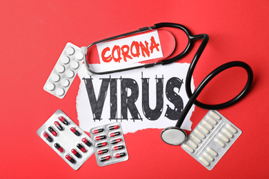 Photo of Flat lay composition with phrase CORONA VIRUS and medicines on red background