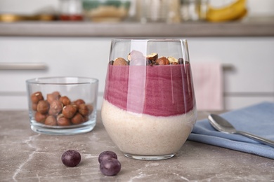 Glass with tasty acai smoothie on gray table