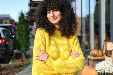 Young woman in stylish yellow sweater outdoors