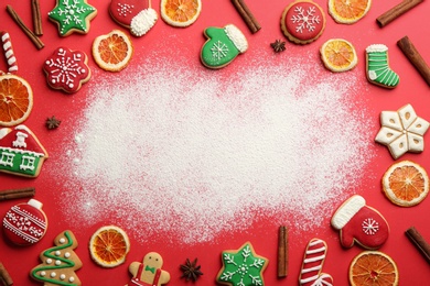 Photo of Frame of Christmas cookies and flour on red background, flat lay. Space for text